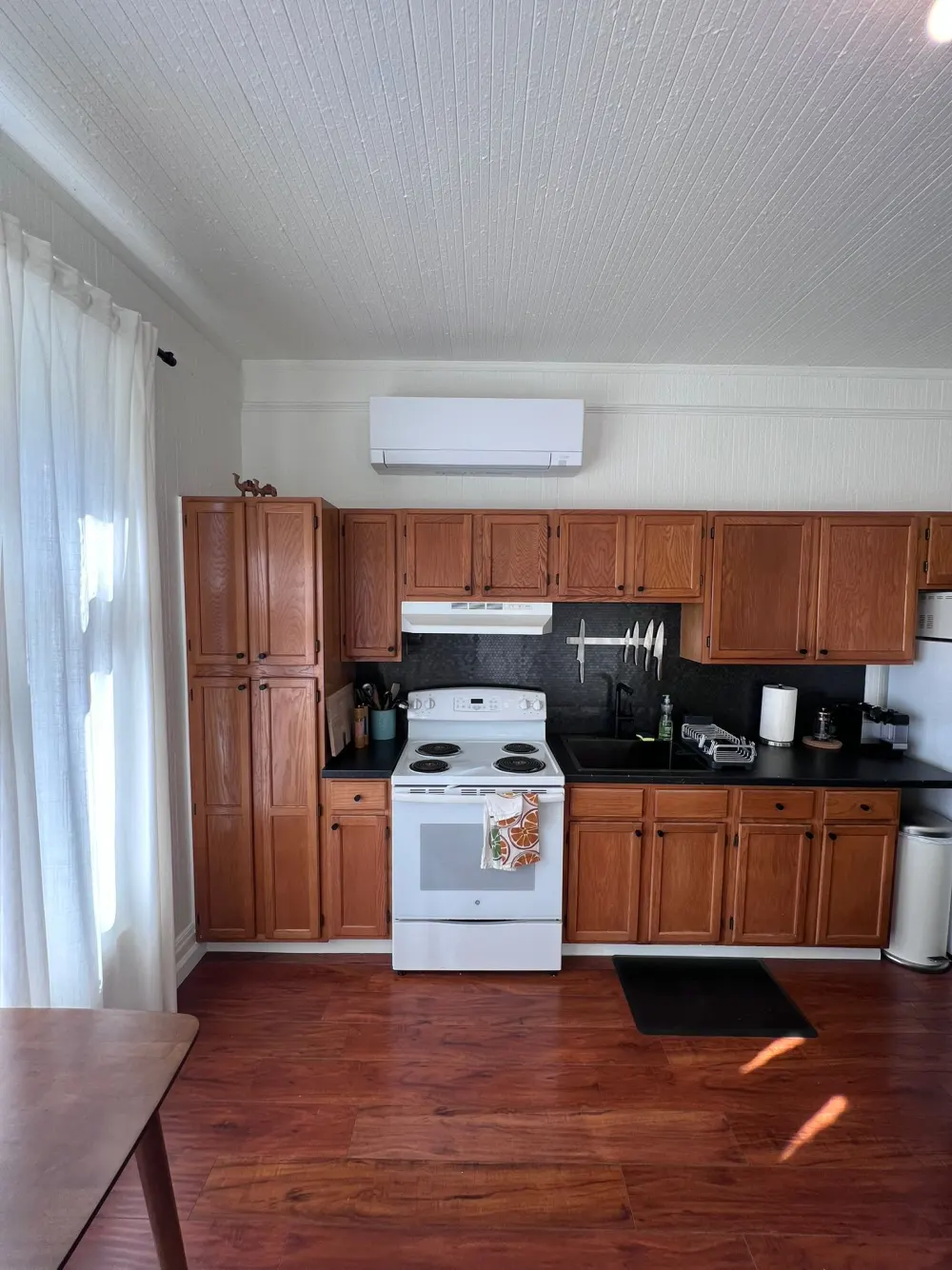 Wall-mounted ductless mini-split head installed above kitchen cabinets