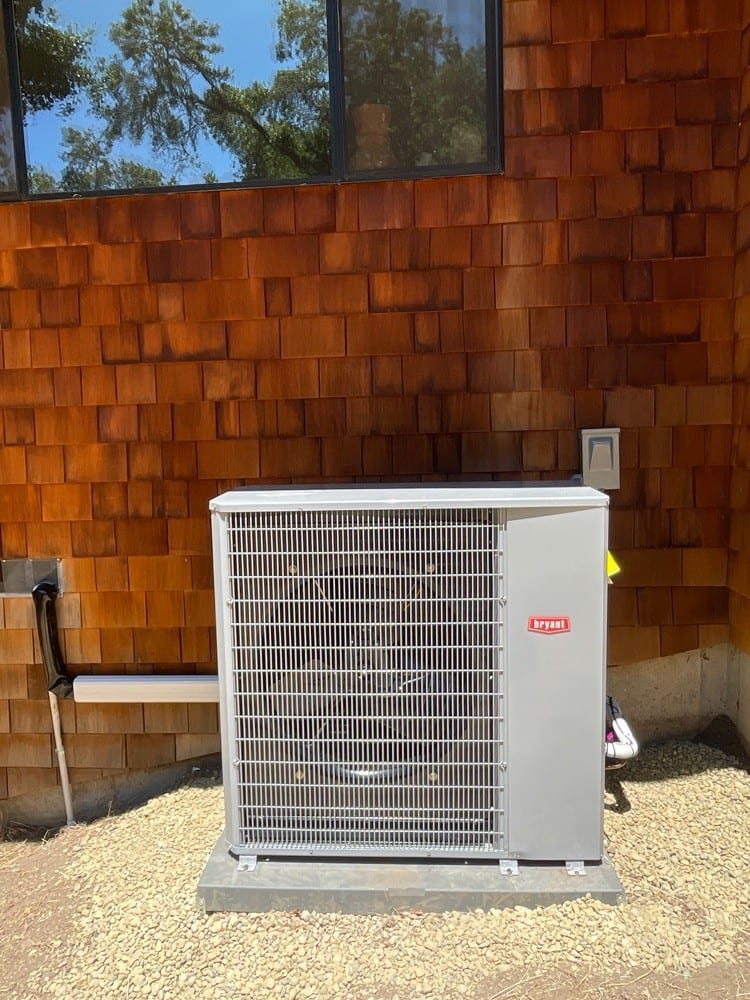 Bryant heat pump outdoor unit installed by Galaxy Heating & Air at a cedar-shingled El Cerrito Hills home