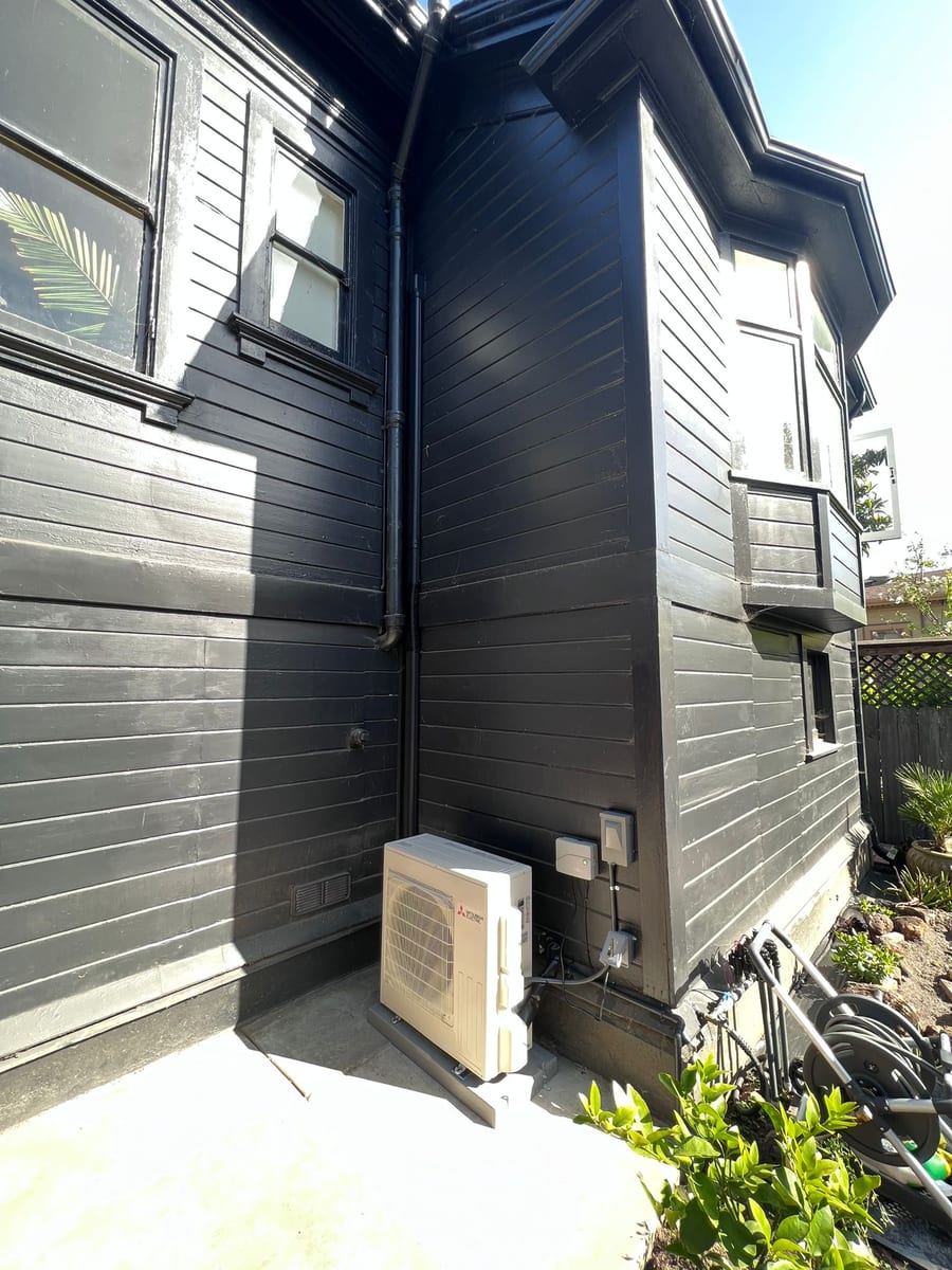Mitsubishi ductless heat pump outdoor unit installed by Galaxy Heating & Air at an Emeryville Victorian home