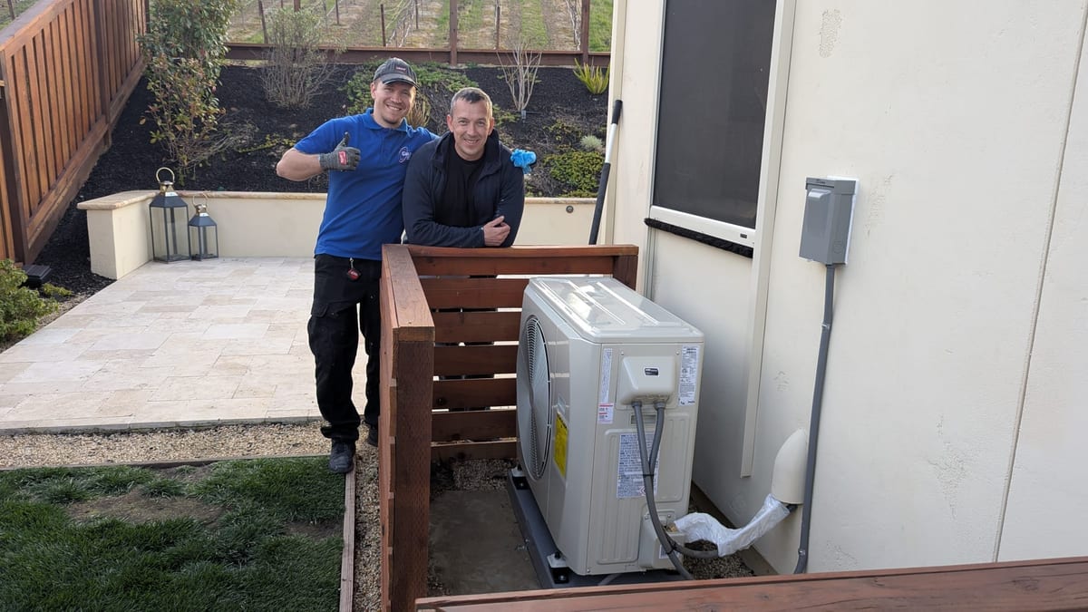 Galaxy Heating & Air installation team with newly installed Mitsubishi ductless heat pump outdoor unit at an Orinda home