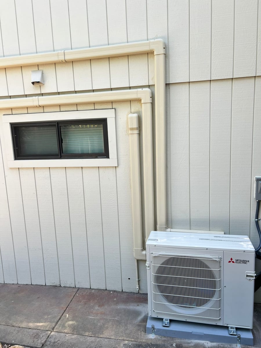 Mitsubishi 3-zone ductless heat pump outdoor unit with painted line-set cover installed by Galaxy Heating & Air at a Walnut Creek home